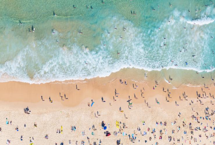 Eine Luftaufnahme von Sonnenanbetern und Surfern am Bondi Beach, Sydney, New South Wales © Daniel Tran
