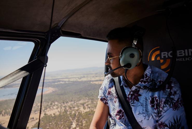 Eine Person in einem Hubschrauber blickt auf die australische Buschlandschaft, Grampians Helicopters, Grampians, Victoria © Tourism Australia 