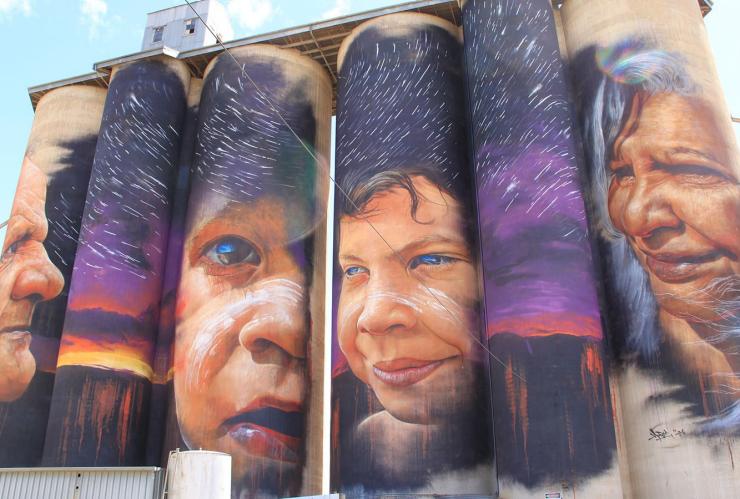 Ein großes Wandgemälde mit Gesichtern auf Silos entlang des Silo Art Trail, Sheep Hills, Victoria © Juddy Roller und Fotografin Nicole Reed 