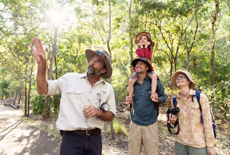 Eine Familie mit Guide blickt während einer Tour mit Offroad Dreaming nach oben in die Baumkronen, Kakadu National Park, Northern Territory © Tourism Australia
