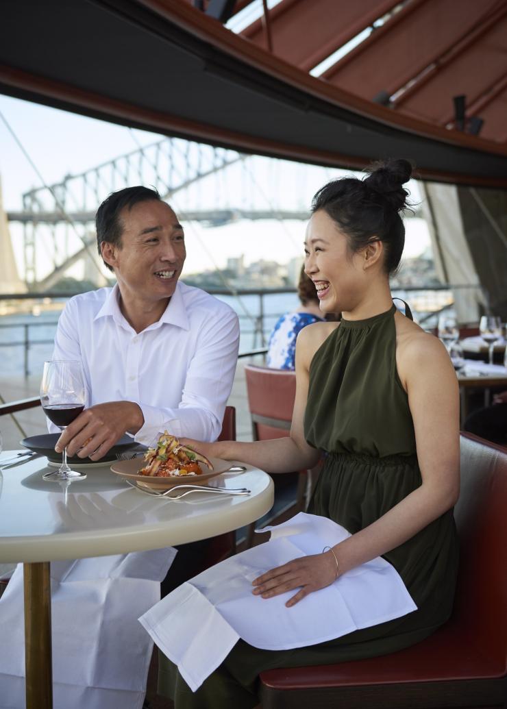Ein Paar genießt das Mittagessen mit Hafenblick im Bennelong Restaurant, Sydney, New South Wales © Destination NSW