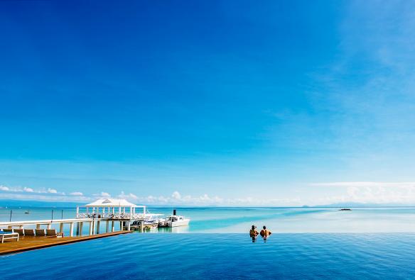 Ein Paar blickt vom Infinity-Pool der Orpheus Island Lodge aus auf den Ozean, Orpheus Island, Queensland © Orpheus Island