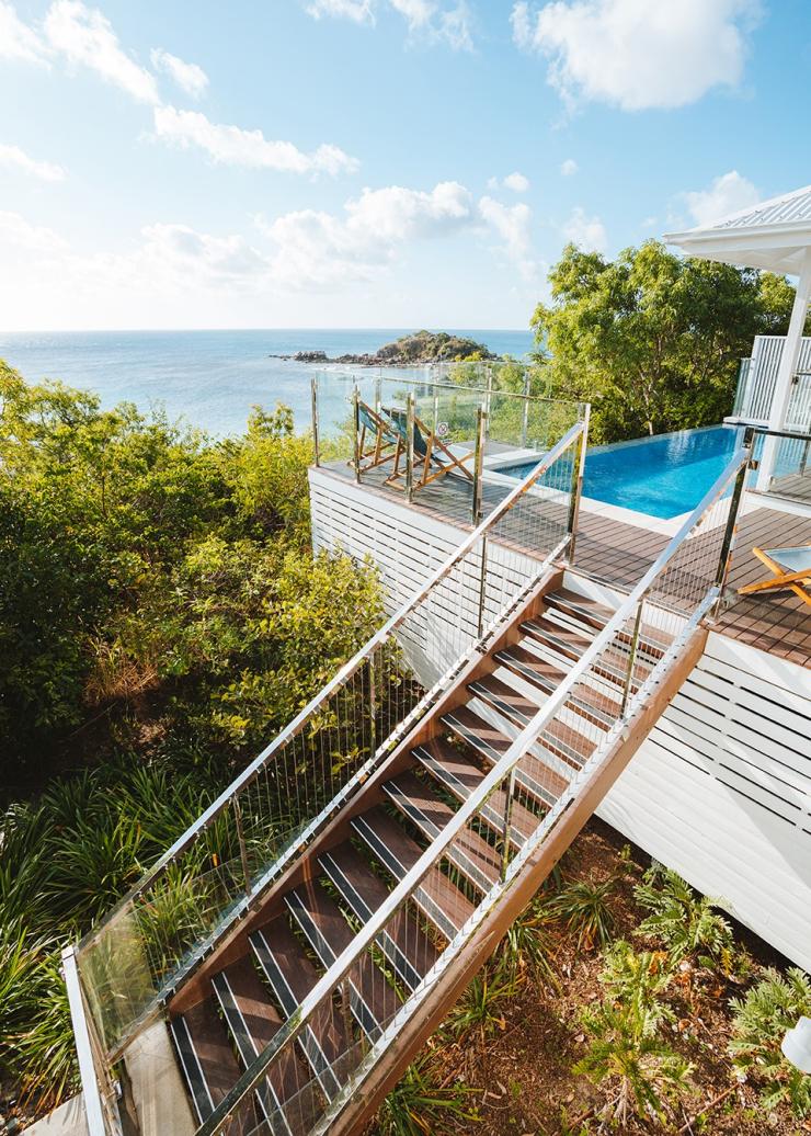 Eine Treppe führt zu einem Pool mit Blick auf den Ozean, Lizard Island Resort, Lizard Island, Queensland © Tourism Australia