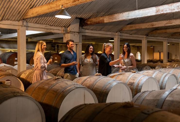 Eine Personengruppe mit Weingläsern in der Hand in einem Weinkeller, Seppeltsfield, Barossa Valley, Südaustralien © South Australian Tourism Commission