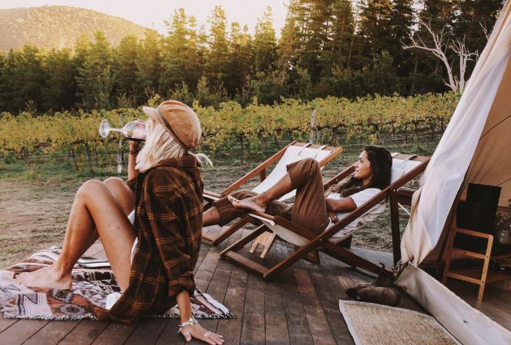 Frauen trinken Wein vor einem Glamping-Zelt von Naked Cubby Co in der Nähe von Canberra, Australian Capital Territory © Naked Cubby Co/Shan Bawden