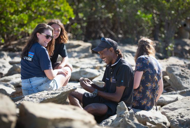Eine Reisegruppe sitzt mit dem Bardi Terry Hunter während einer Borrgoron Coast to Creek Tours inmitten der Mangroven, Dampier Peninsula, Westaustralien © Tourism Australia