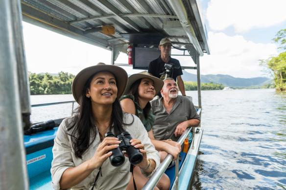 Eine Ausflugsgruppe mit Ferngläsern auf einem Flussboot mit FNQ Nature Tours, Daintree Rainforest, Queensland © Tourism Tropical North Queensland