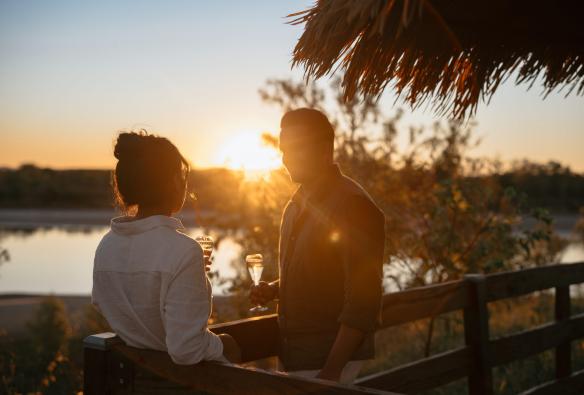 Couple having a drink at sunset on the deck at Bullo River Station, Baines, Northern Territory © Tourism Australia