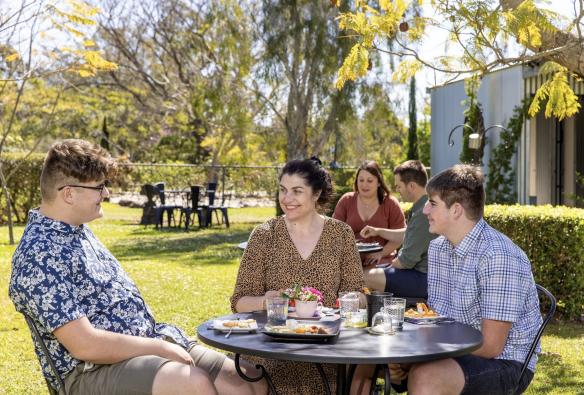 Group of people eating a meal in a garden, Towri Sheep Cheeses, Allenview, Queensland © Tourism Australia