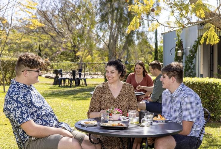 Group of people eating a meal in a garden, Towri Sheep Cheeses, Allenview, Queensland © Tourism Australia