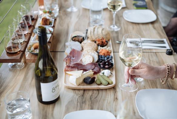 A wine tasting is set up on an outdoor table with a grazing board of cheese and crackers at Wines, Riverina, New South Wales © Tourism Australia