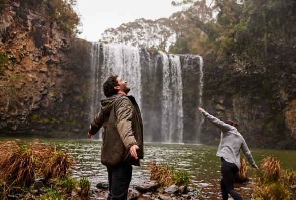 A couple explores a waterfall in Dorrigo, New South Wales © Destination NSW