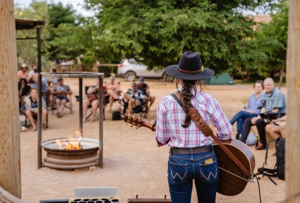 A woman playing a guitar for guests of Bullara Station, Ningaloo, Western Australia © Tourism Australia 