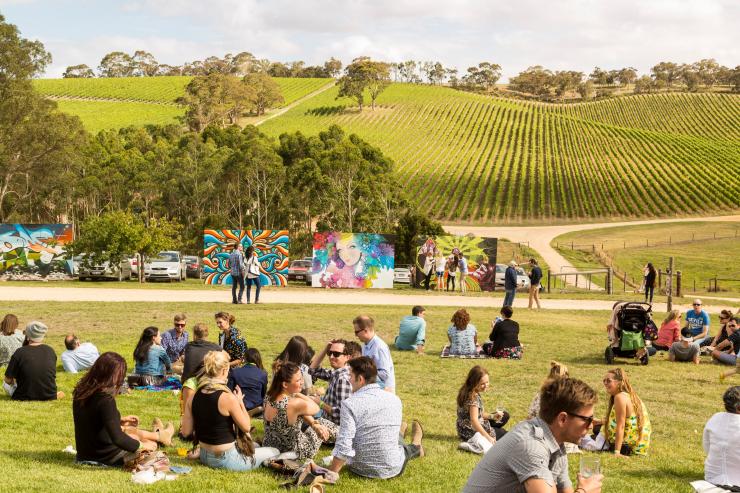 Groups of people having picnics on a grassy field overlooking vineyards at The Piece Project, Longview Vineyard, Adelaide Hills, South Australia © Adelaide Photographers