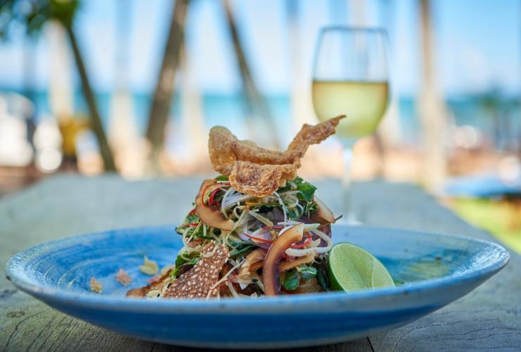A fresh, carefully plated dish with a glass of white wine, Nu Nu Restaurant, Palm Cove, Queensland © Tourism and Events Queensland