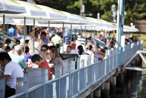 A crowd of people sitting on a pier eating seafood, Sydney Fish Market, Sydney, New South Wales © Destination NSW