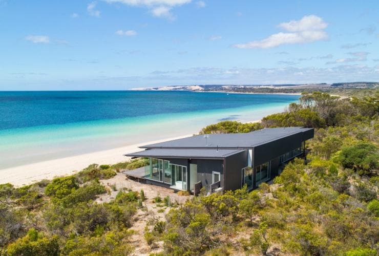 A building tucked within bushland overlooking a white sand beach, One Kangaroo Island, Kangaroo Island, South Australia © South Australian Tourism Commission