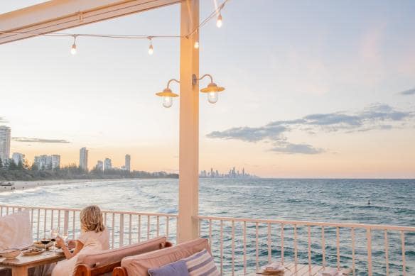 Woman enjoys coastal dining overlooking the ocean at Burleigh Pavilion, Gold Coast, Queensland © Destination Gold Coast