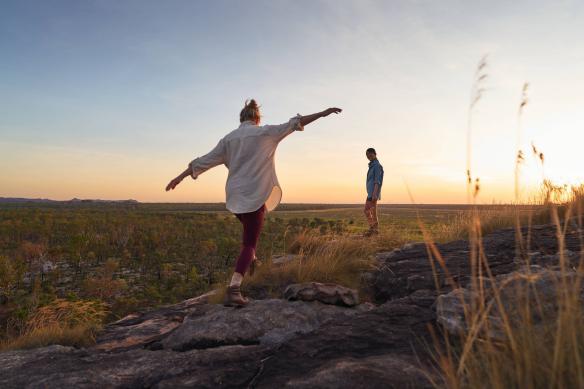 Two women walk over rocky terrain at sunset in Kakadu National Park, Northern Territory © Tourism & Events NT/Safari Global