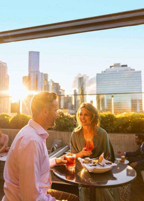 A couple enjoying drinks on a rooftop bar in Melbourne, Victoria © Tourism Australia