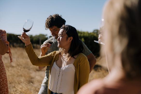 Woman swirls a glass of red wine at Passel Estate, Margaret River, Western Australia © Tourism Australia 