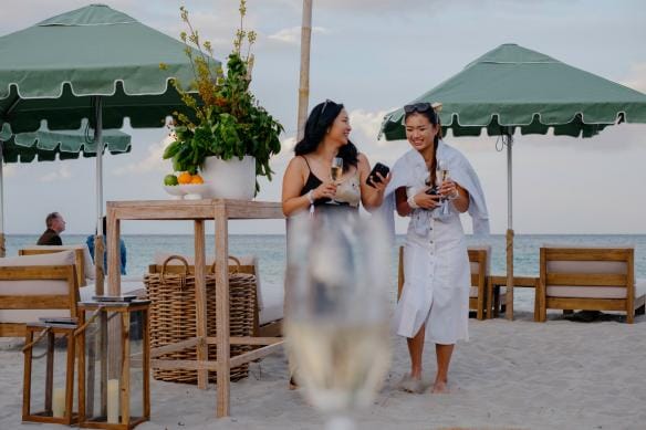 Two woman walk on the sand with wine in hand at Pair'd, Margaret River, Western Australia © Tourism Western Australia 