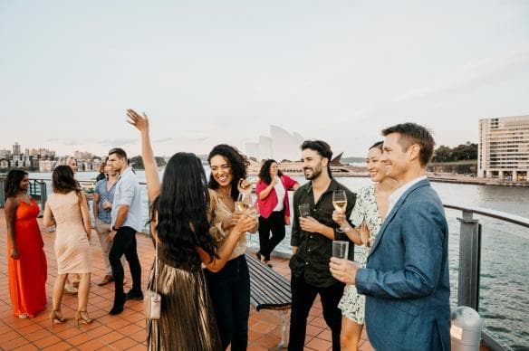 Friends with drinks in hand in The Rocks neighbourhood of Sydney, New South Wales © Destination NSW