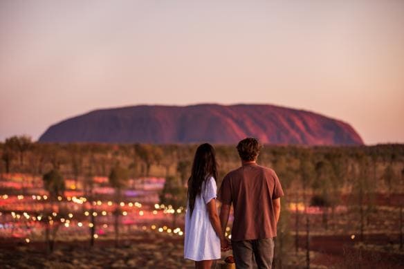 A couple admiring the many colourful bulbs of the Field of Light, Uluru-Kata Tjuta National Park, Northern Territory © Tourism NT/The Salty Travellers