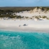 Couple sunbathing on the beach next to 4WD at Cape Le Grand National Park © Australia's Golden Outback