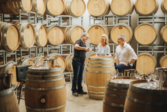Couple tasting red wine surrounded by wine barrels at Tobin Wines, Queensland Country, Queensland © Tourism and Events Queensland