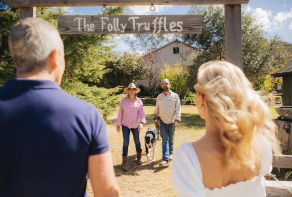 Two farm owners and their truffle-hunting dog welcome visitors to their truffle farm, The Folly Truffles, Queensland Country, Queensland © Tourism and Events Queensland