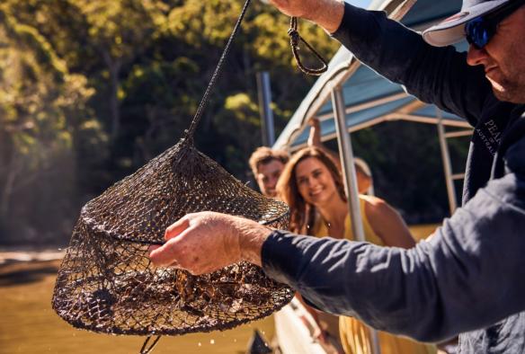 Guide showing guests the pearl lines at the Broken Bay Pearl Farm, Mooney Mooney, New South Wales © Destination NSW