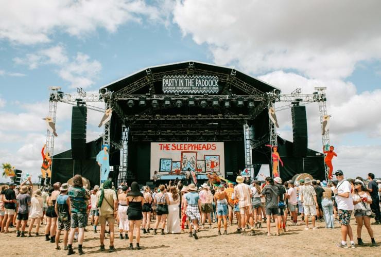 A crowd of people gathered around a stage in a paddock during a festival, Party in the Paddock, Carrick, Tasmania © Zoe Lowry