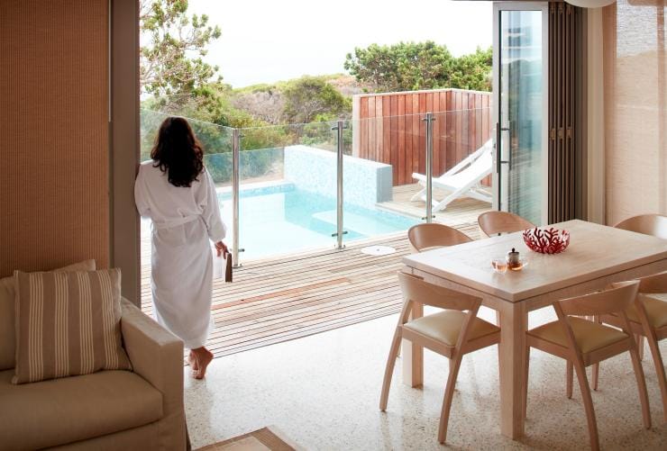 A woman wearing a robe leaning against the large opening to her private deck and plunge pool at Injidup Spa Retreat, Margaret River, Western Australia © Injidup Spa Retreat