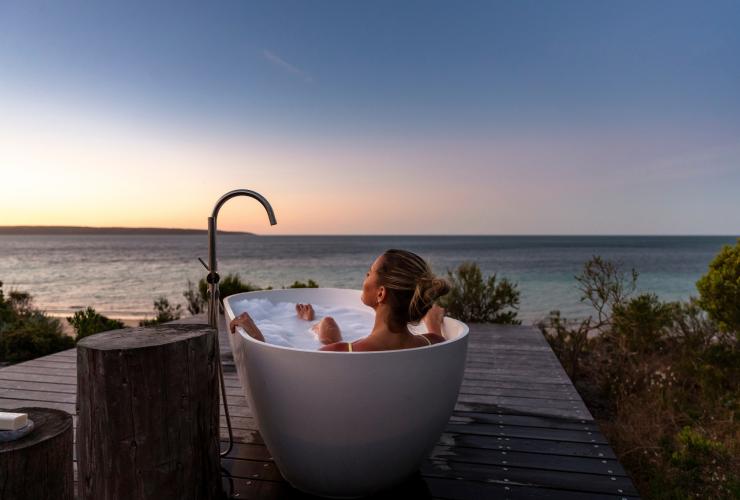 A person in an outdoor tub overlooking the ocean, One Kangaroo Island, Kangaroo Island, South Australia © South Australian Tourism Commission