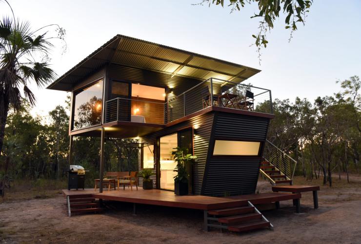 A tiny home with glowing lights during dusk surrounded by bushland, Hideaway Litchfield, Northern Territory © Hideaway Litchfield/Simeon Latham