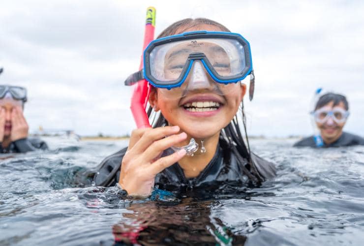 A child swimming in the ocean with a snorkel on while smiling, Dolphin Discovery Centre, Bunbury, Western Australia © WOW!-Photography