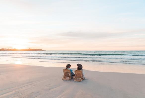 A couple sitting on an empty beach at sunset in Robe, Limestone Coast, South Australia © Mish and Kirk