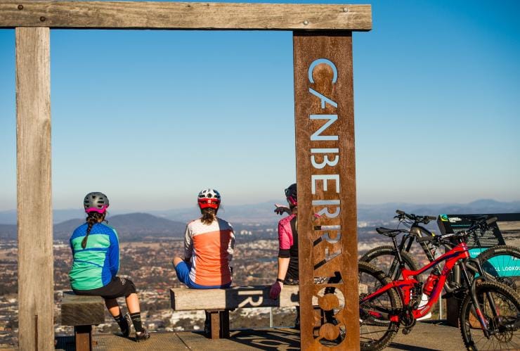 A group of cyclists resting at a lookout overlooking the city along the Centenary Trail, Canberra, Australian Capital Territory © Damian Breach/Visit Canberra