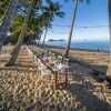 A long table on a white sand beach surrounded by palm trees, Nu Nu Restaurant, Palm Cove, Queensland © Tourism Tropical North Queensland 