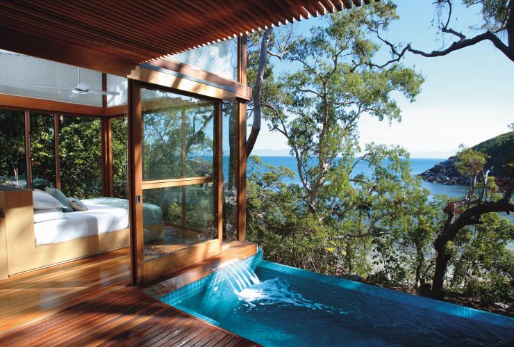 A plunge pool beside a bed in a window-filled room, surrounded by green trees with the blue ocean visible through the leaves at Bedarra Island Resort, Great Barrier Reef, Queensland © Bedarra Island