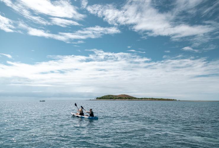 Two people kayaking in the blue ocean with an island in the distance at Camp Island Lodge, Whitsundays, Queensland © Camp Island Lodge
