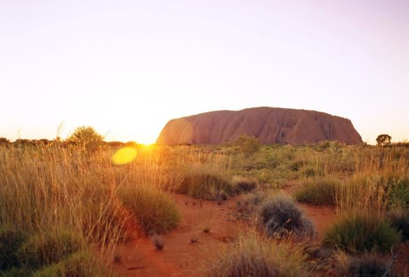 The sunrise casting orange hues across Uluru and the surrounding landscape, Uluru-Kata Tjuta National Park, Northern Territory © Tourism Australia