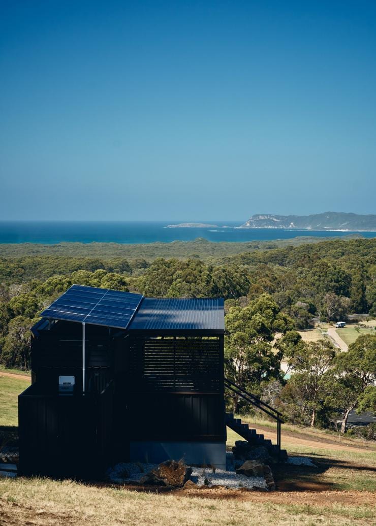 Aerial view over a tiny home surrounded by bushland with a coastline in the distance, Heyscape Denmark, Australia's Southwest, Western Australia © Aquabumps / Heyscape