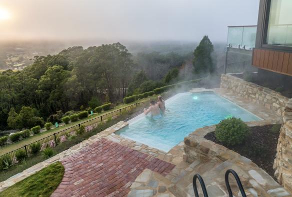 A couple in a mineral pool looking out over the hills, Sequoia Lodge, Crafers, South Australia © Tourism Australia