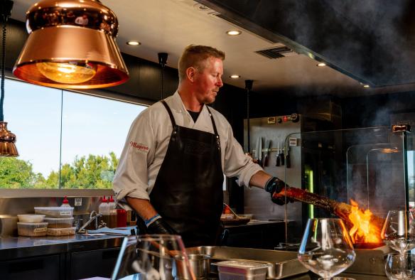 Chef cooking over flame at Mayura Station, South Australia © South Australian Tourism Commission