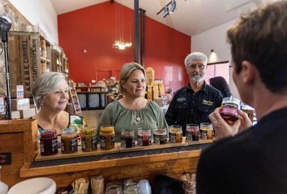 Customers sample a range of jams and chutneys with Fillipos Tours at Jamworks Gourmet Foods, Southern Queensland Country, Queensland © Tourism Australia