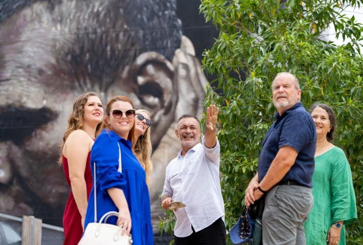Tour group paused in a circle listening to the tour guide, Darwin Gourmet Tour, Darwin, Northern Territory © Tourism Australia