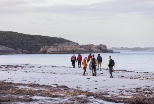 Group hiking on the beach in Albany, Western Australia © Susan McCabe t/as Busy Blue Bus Tours