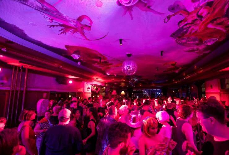 A venue filled with people dancing beneath a painted roof under pink and purple lights at the Imperial Hotel, Erskineville, Sydney, New South Wales © Destination NSW